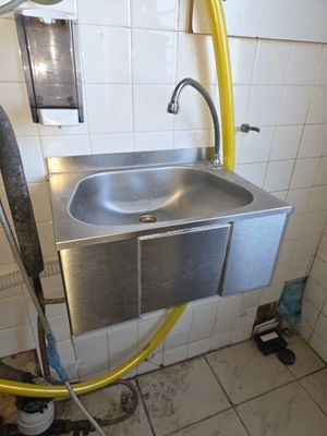 un lavabo muni d'un tuyau d'arrosage dans une salle de bains