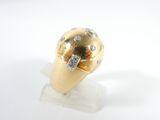 a gold ring with diamonds on it on a white surface