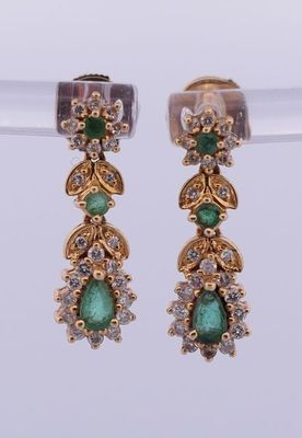 une photo d'une paire de boucles d'oreilles ornées de pierres vertes