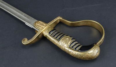 a close up of a sword on a table with a black background