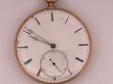 a gold pocket watch with roman numerals on the face