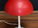 a red lamp that is on a wooden table