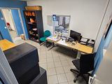 vue d'une pièce avec un bureau, une chaise et un écran d'ordinateur