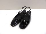 a pair of black shoes sitting on top of a white table