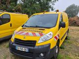 two yellow vans parked next to each other in a field