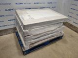 une pile de matelas posée sur une palette devant un mur