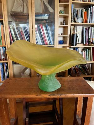 a green vase sitting on top of a wooden table