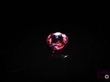 a close up of a pink diamond on a black surface