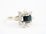 un gros plan d'une bague ornée d'un diamant bleu entouré de diamants blancs