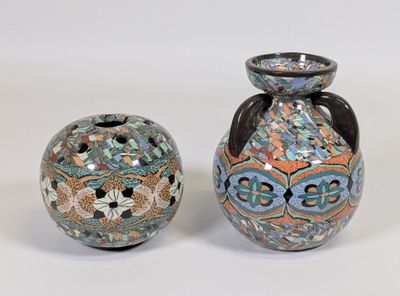 deux vases posés l'un à côté de l'autre sur une surface blanche