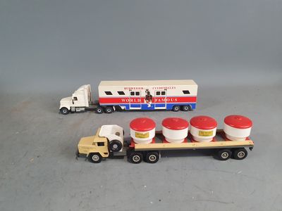 a toy truck and a toy bus on a gray surface