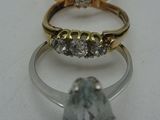 trois anneaux de couleurs différentes, sertis de diamants, sur un fond blanc
