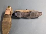 pair of tan sued slippers on a grey surface