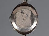 a close up of a silver watch with a chain around it