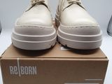 les chaussures se trouvent dans une boîte posée sur une surface blanche