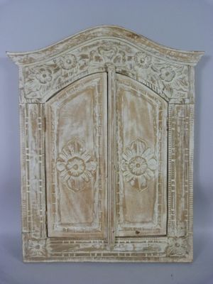 une image représentant un meuble en bois à deux portes, ornées de sculptures