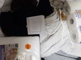 a pile of clothes and toilet paper on a bed