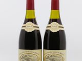 deux bouteilles de vin rouge posées l'une à côté de l'autre sur une surface blanche
