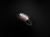 gros plan d'une bague en argent sur une surface noire