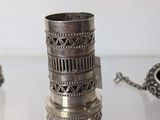 a silver cup sitting on a table with a chain around it