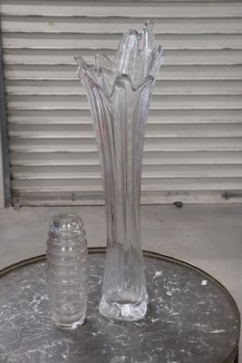 a glass vase and salt shaker sitting on a table