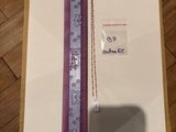 une boîte ornée d'un ruban violet et d'une étiquette blanche
