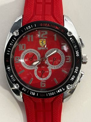 Montre Ferrari avec bracelet en caoutchouc rouge sur fond blanc