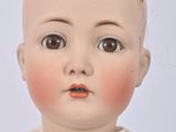 a close up of a doll with a red dress on