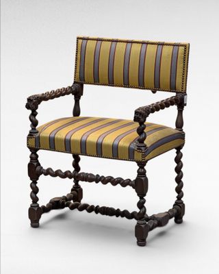 a wooden chair with striped upholstered seat and arms