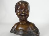 a close up of a bronze bust of a child