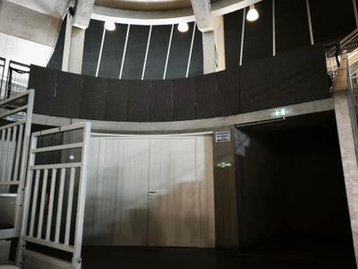 une image représentant une pièce avec un escalier et une fenêtre ronde