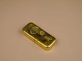 a gold bar sitting on a white surface