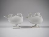 two white vases sitting on top of each other on a table