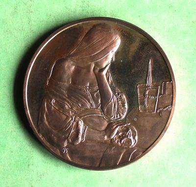 a close up of a coin on a green surface with a picture of a woman