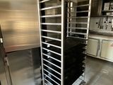 une cuisine équipée d'un four en inox et de nombreuses étagères