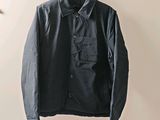 the jacket is hanging on a hanger in the corner of the room