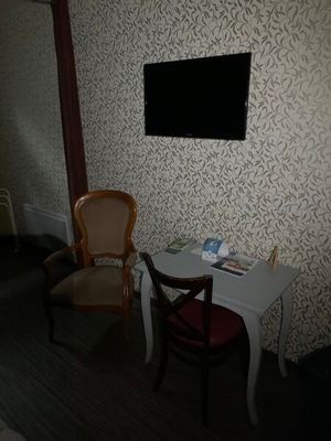une petite table avec deux chaises devant un téléviseur à écran plat