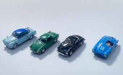 quatre petites voitures sont alignées sur une surface blanche