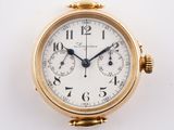 a close up of a gold watch on a white surface