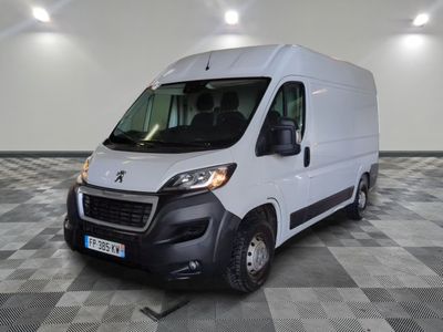 la camionnette blanche est garée sur un sol en damier dans le garage
