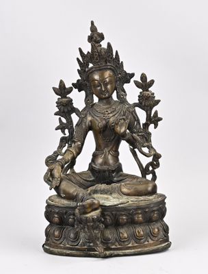 une statue en bronze d'une femme assise sur un rocher