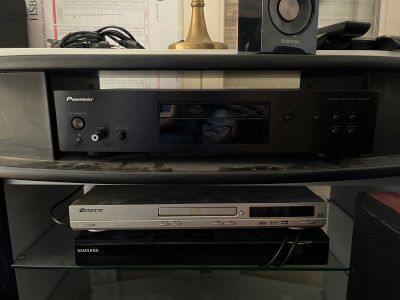 une photo d'une chaîne hi-fi posée sur une étagère en verre