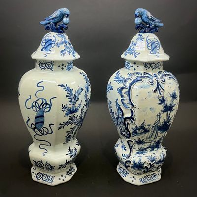 pair of blue and white vases with birds on top of them