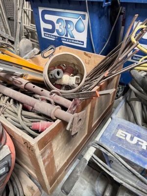 une boîte remplie d'outils posée sur un tas de bric-à-brac