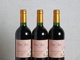 trois bouteilles de vin posées sur une table en bois