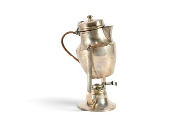 une cafetière en argent munie d'une anse et posée sur un socle