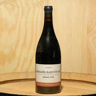 a bottle of wine sitting on top of a wooden barrel