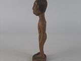 a small wooden statue of a man standing on a pedestal