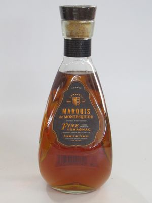 une photo d'une bouteille de brandy posée sur une surface blanche
