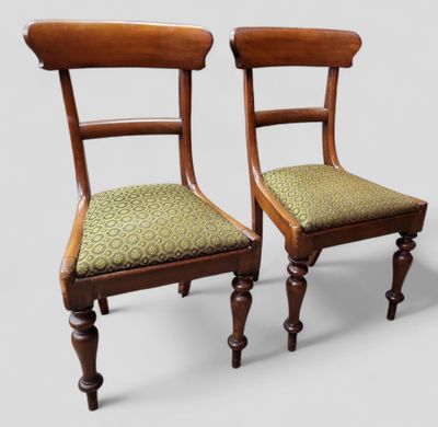deux chaises en bois avec des coussins rembourrés verts posés dessus